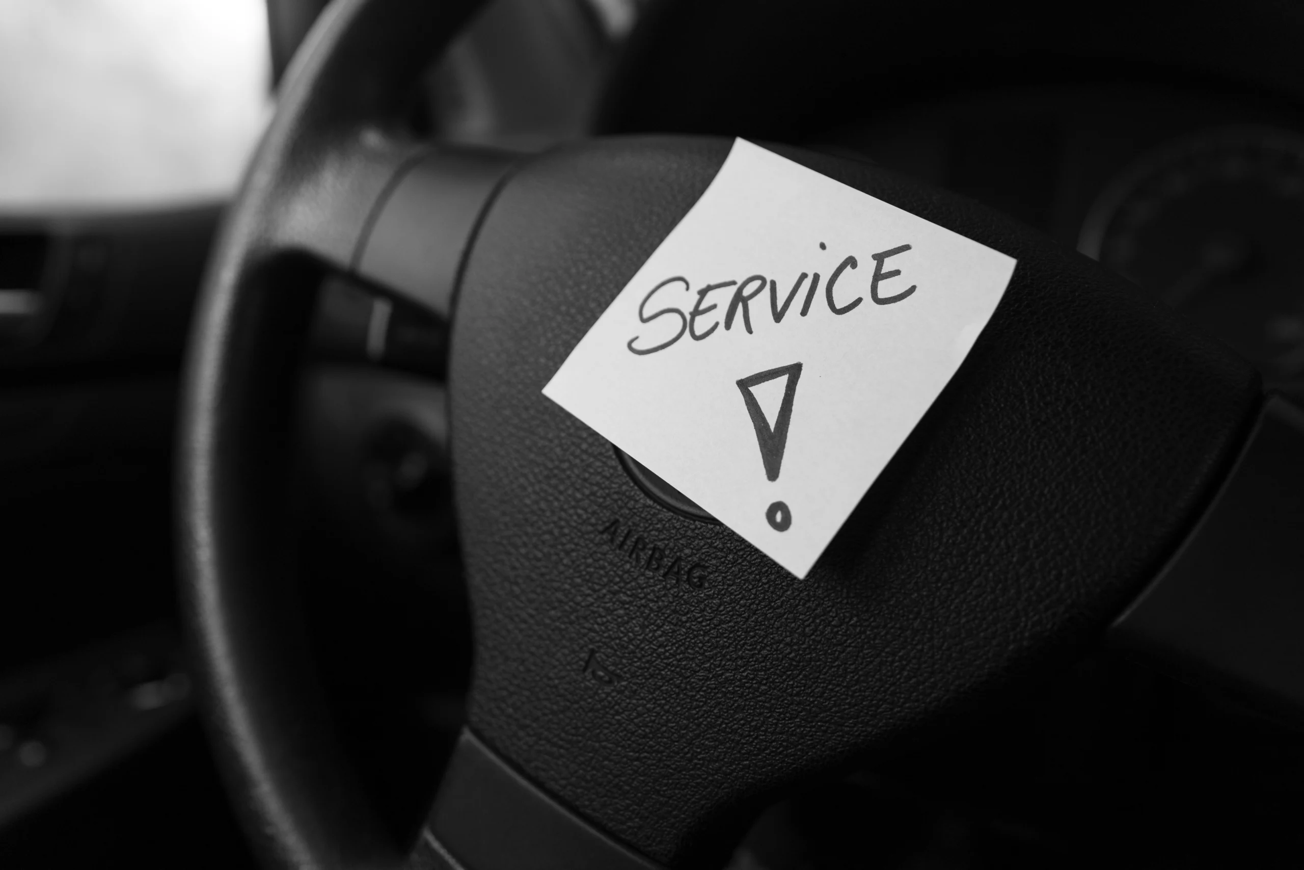Writing service on memo post reminder. Text on sticky paper inside car dashboard.