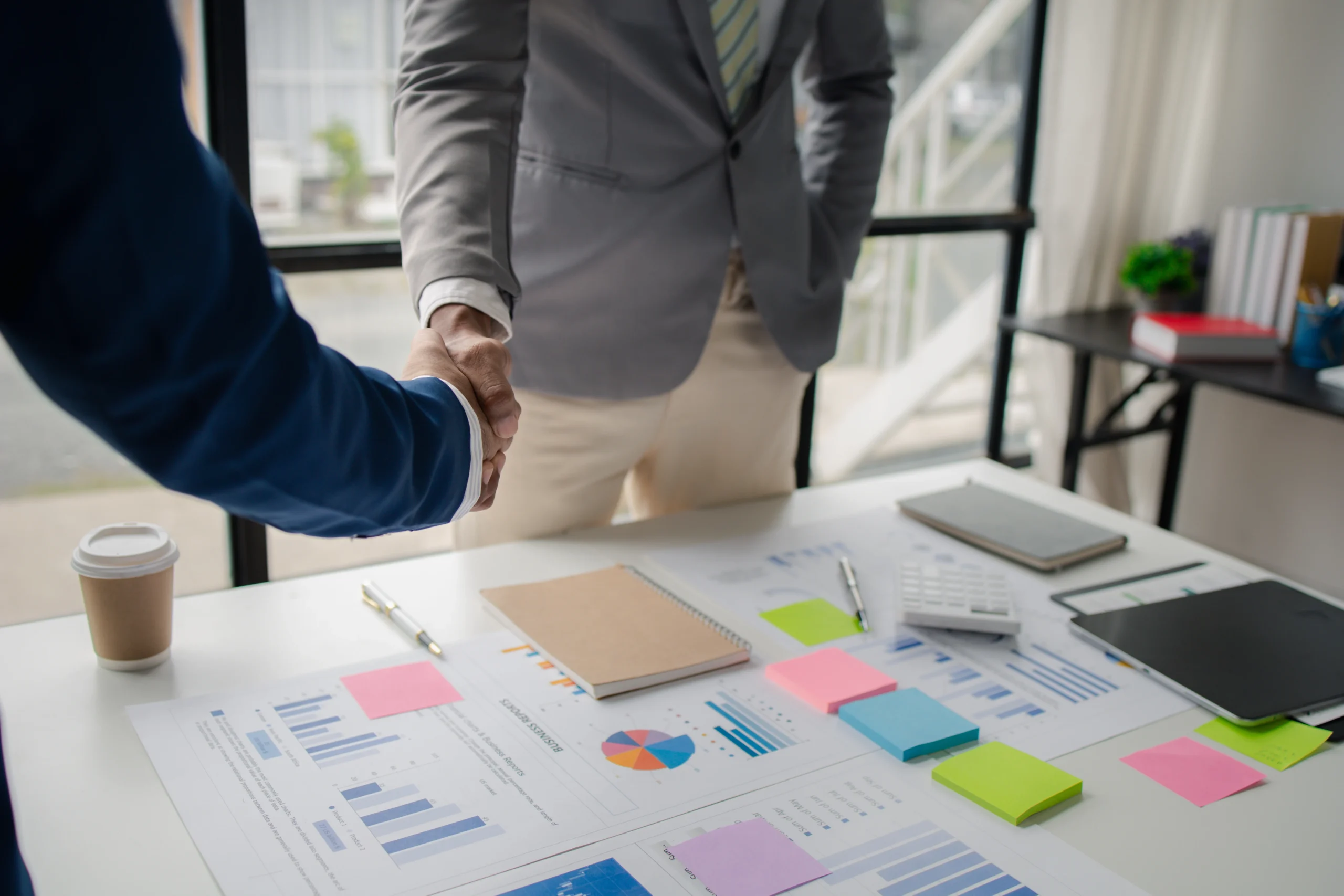Two business men shake hands, Two businessmen are agreeing on business together and shaking hands after a successful negotiation.